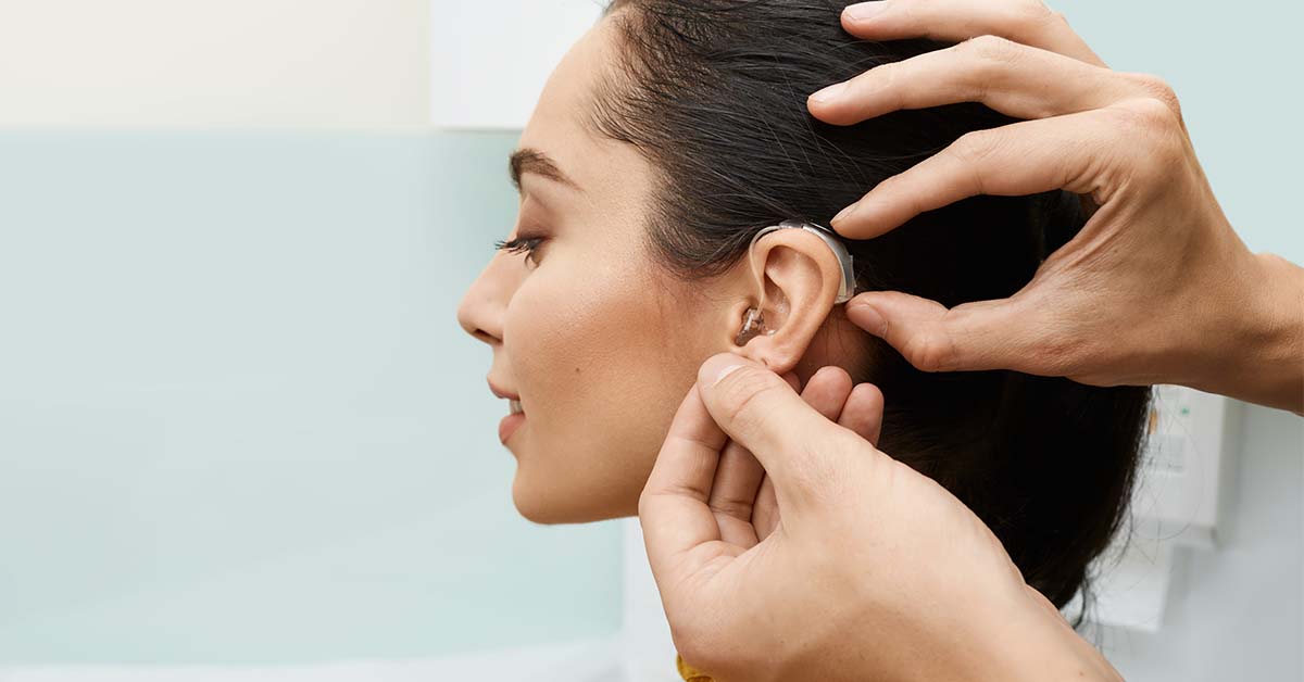 Audiologist fits hearing aid
