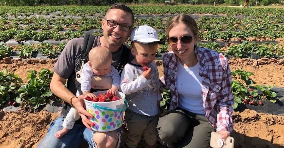 Dr. Alexander A. Foster of BayCare Clinic Eye Specialists poses with his family in a field of strawberries.